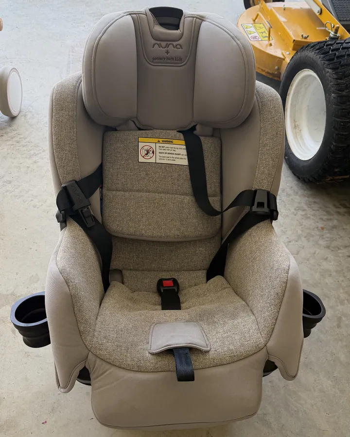 A beige convertible car seat with dingy fabric before cleaning