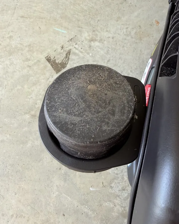 A car seat cup holder coated in dust and grime